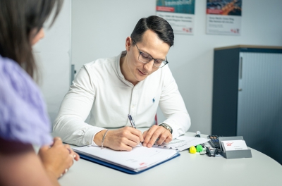 LBS-Berater macht sich im Gespräch mit einer Kundin Notizen.